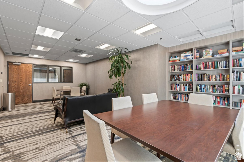 Dining area with a paneled ceiling and carpet floors