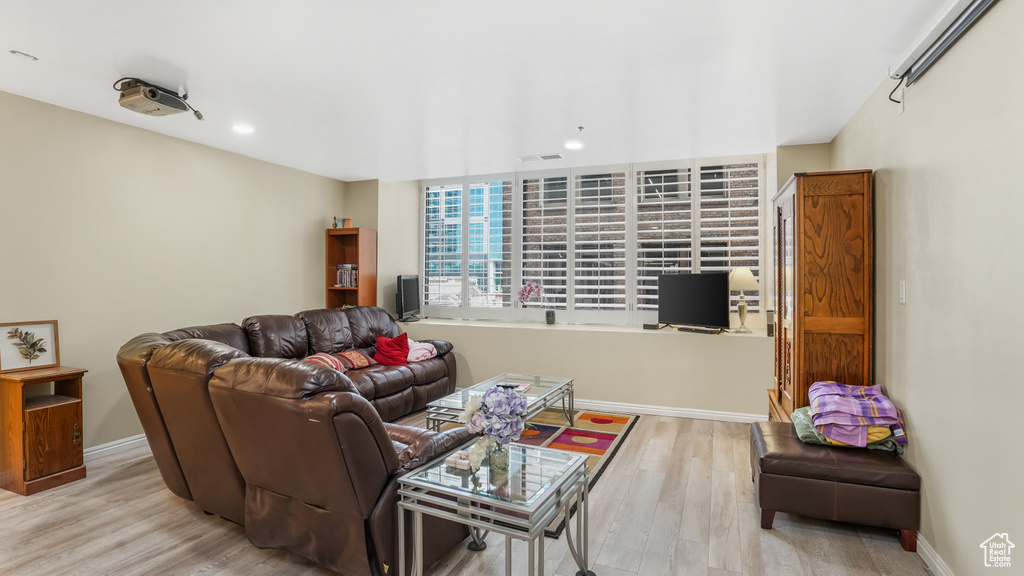 Living room with light wood-type flooring, recessed lighting, and baseboards