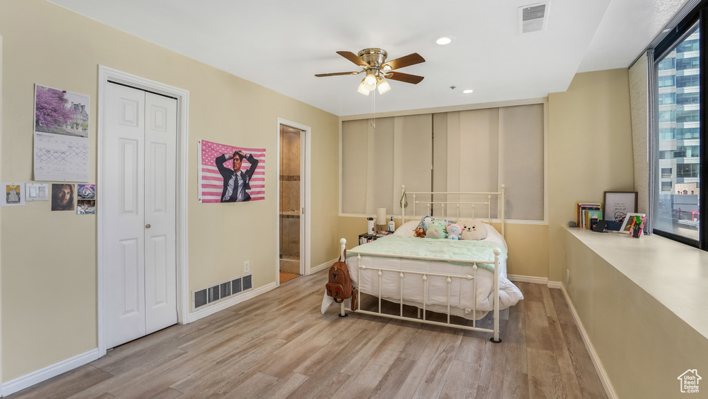 Bedroom with wood finished floors, baseboards, recessed lighting, a closet, and ensuite bath