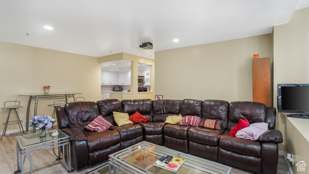 Living room featuring light wood-style flooring, recessed lighting, and baseboards