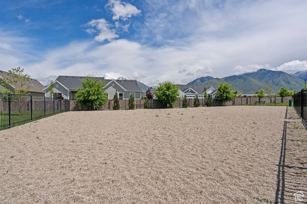 View of yard with fence, a residential view, and a mountain view