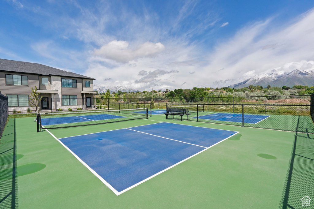 View of tennis court featuring fence, community basketball court, and a mountain view