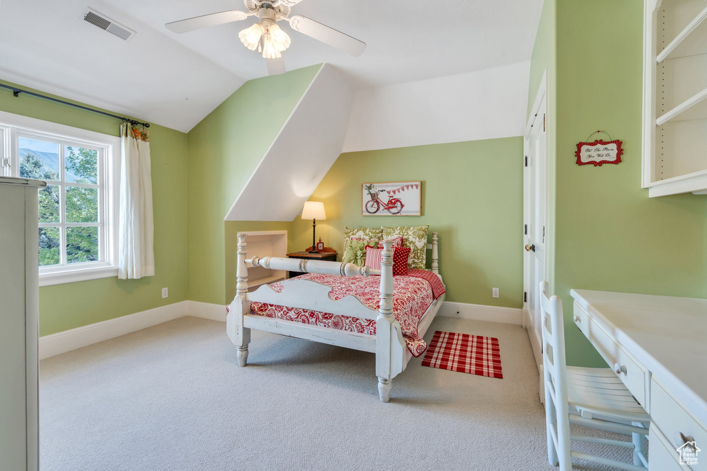 Carpeted bedroom with lofted ceiling, baseboards, and ceiling fan