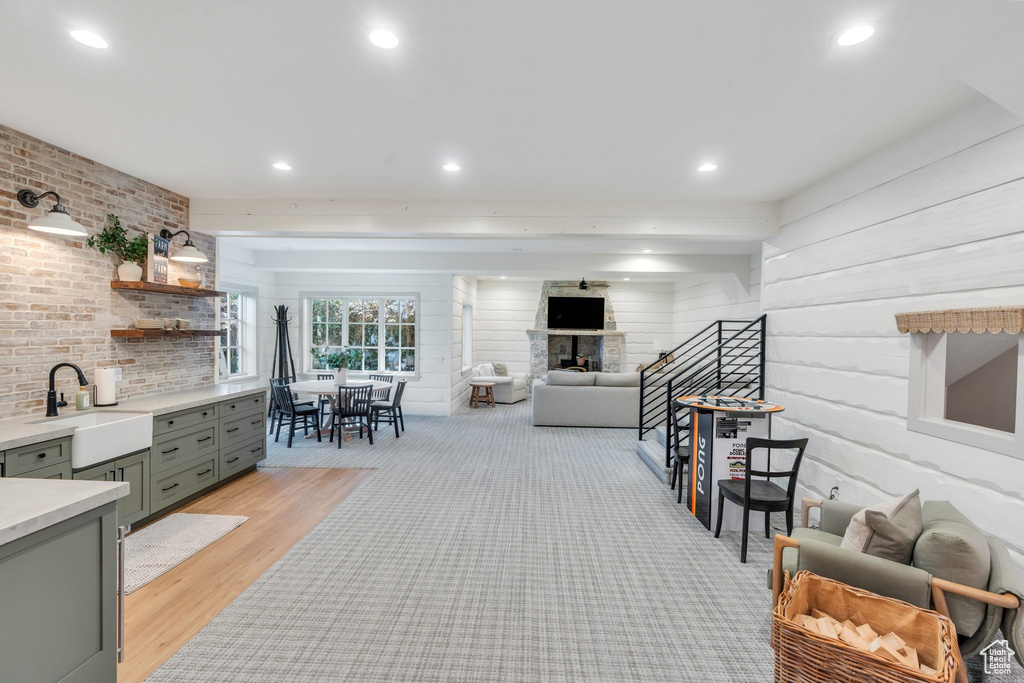 Living room with light wood-type flooring, recessed lighting, and a fireplace