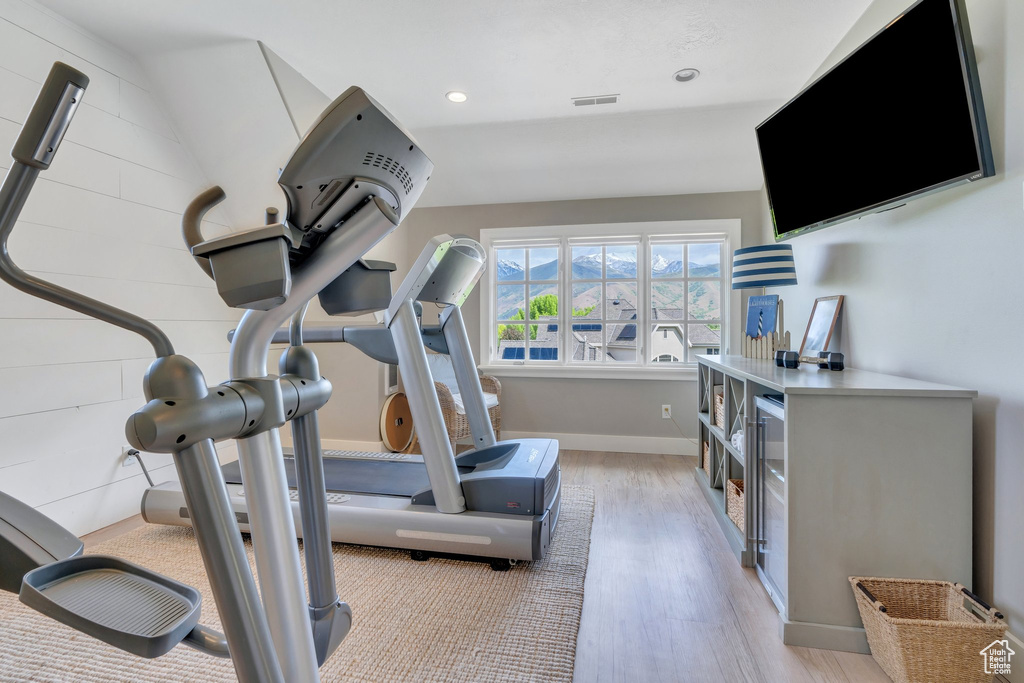 Workout area with light wood-style floors, baseboards, and recessed lighting