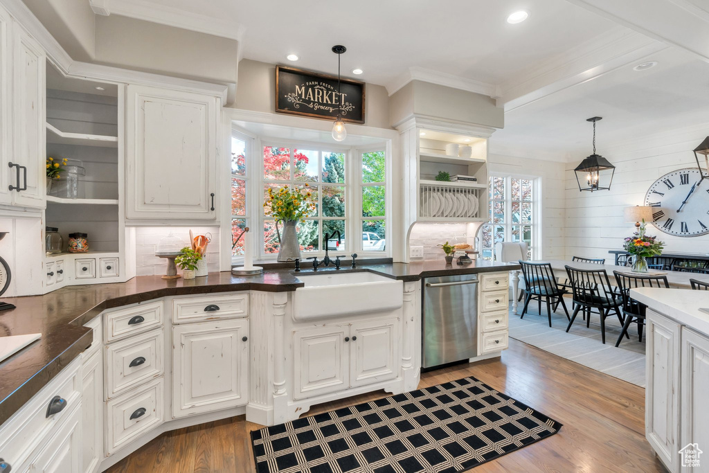Kitchen featuring dishwasher, white cabinets, a sink, dark countertops, and open shelves