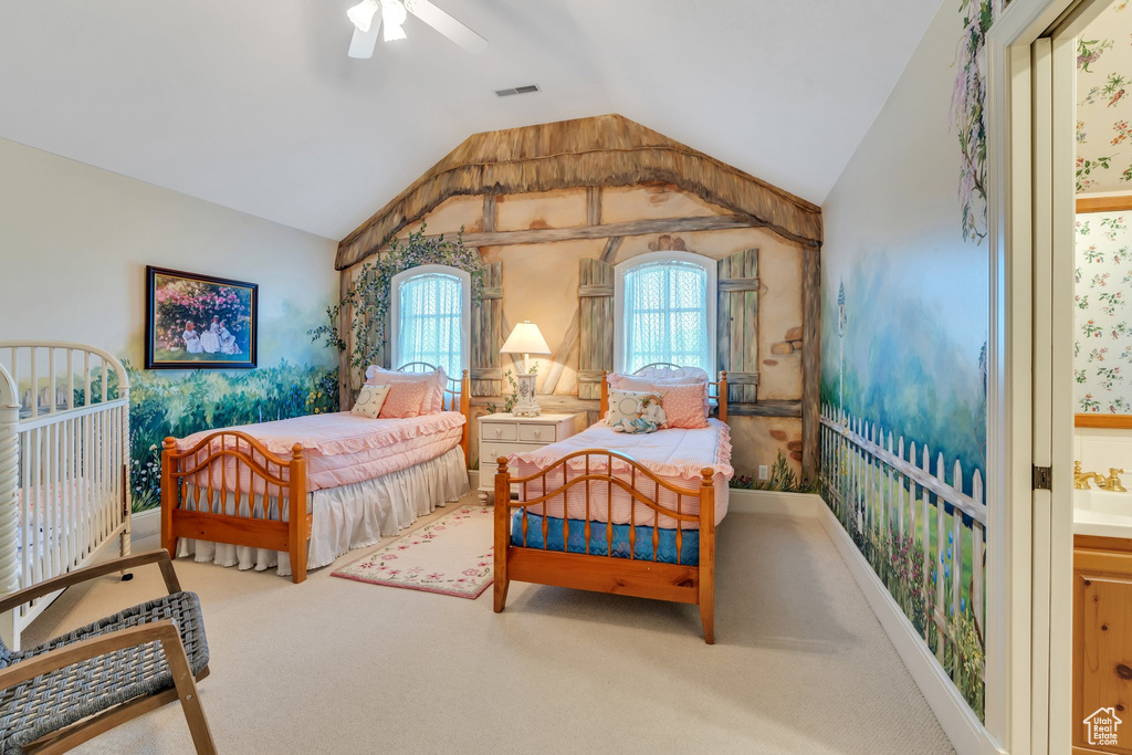 Bedroom with lofted ceiling, carpet, ensuite bathroom, a ceiling fan, and wallpapered walls