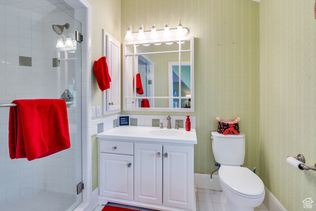 Full bath featuring a shower stall, toilet, vanity, and tile patterned flooring