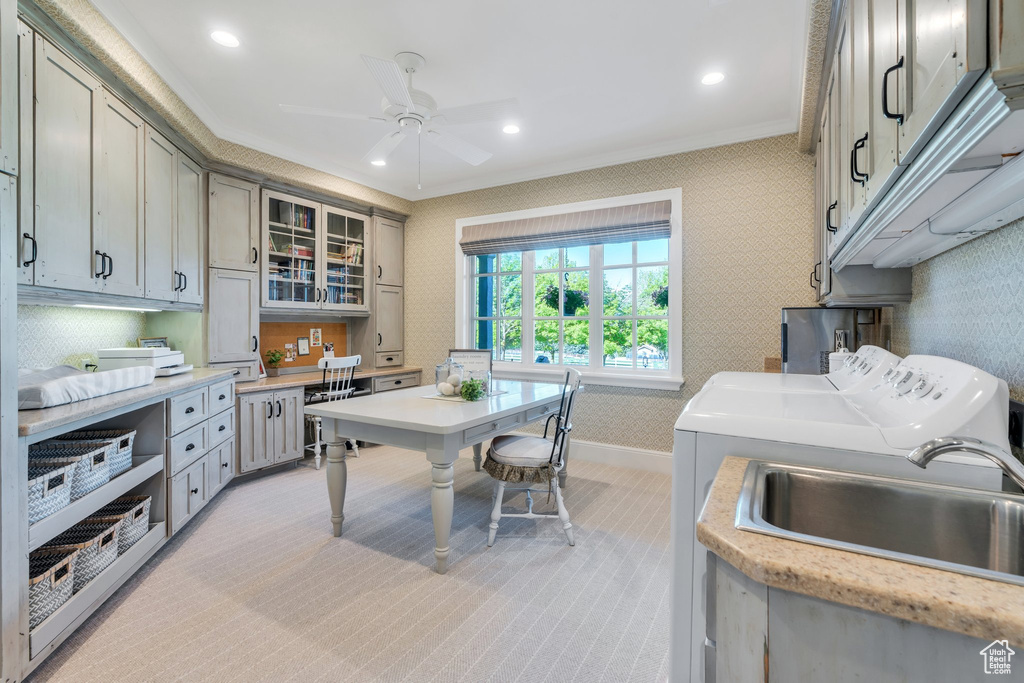 Kitchen featuring washer and clothes dryer, wallpapered walls, ornamental molding, light countertops, and a ceiling fan