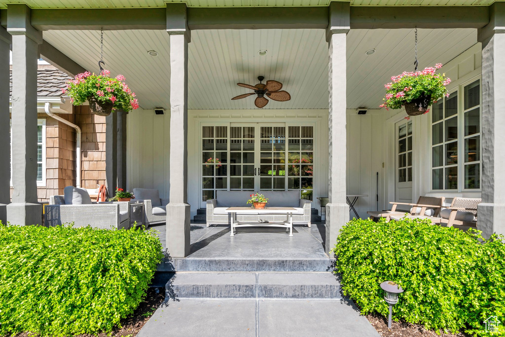 Property entrance featuring a porch, ceiling fan, and an outdoor living space
