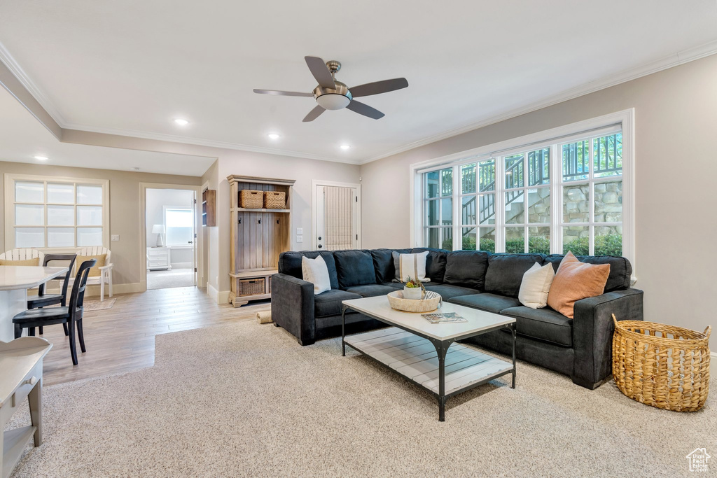 Living area with healthy amount of natural light, a ceiling fan, crown molding, recessed lighting, and baseboards
