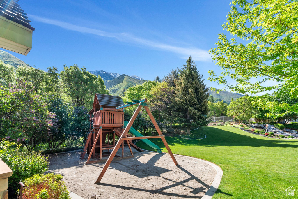 View of play area with a mountain view and a yard