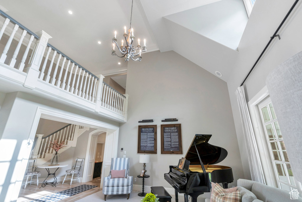 Living area with high vaulted ceiling, arched walkways, a chandelier, baseboards, and recessed lighting
