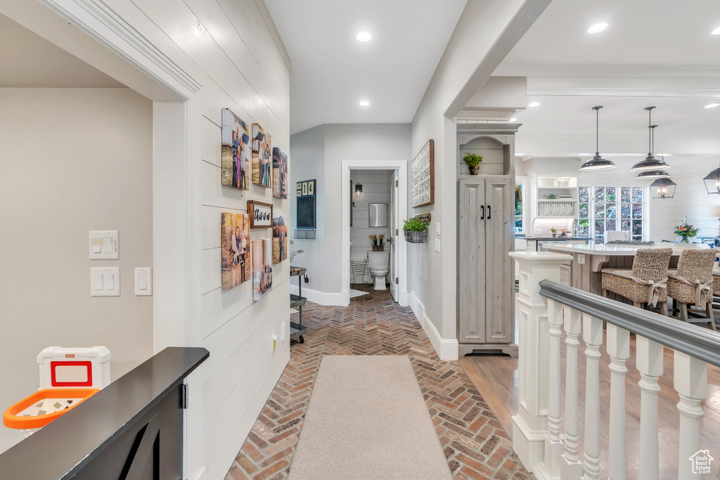 Hallway with baseboards, brick flooring, and recessed lighting