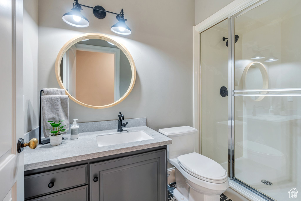 Full bath featuring toilet, a stall shower, and vanity