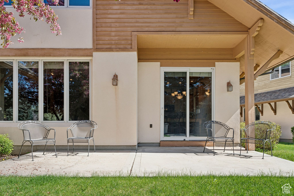 View of exterior entry featuring a patio area and stucco siding