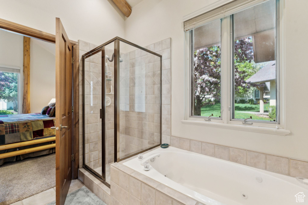 Bathroom featuring ensuite bathroom, a shower stall, and a tub with jets