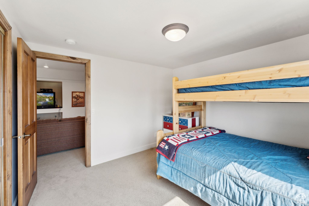 Bedroom with light colored carpet and baseboards