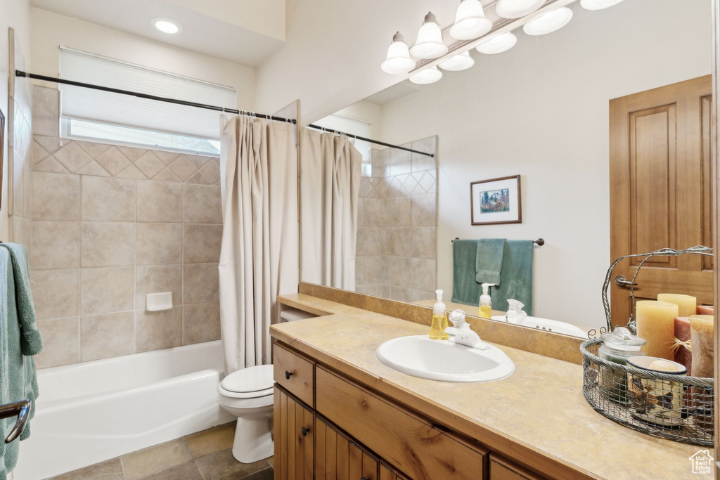 Bathroom featuring toilet, shower / bath combo, and vanity