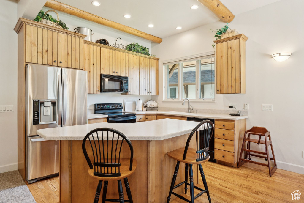 Kitchen with black microwave, electric range oven, stainless steel fridge with ice dispenser, a sink, and dishwasher