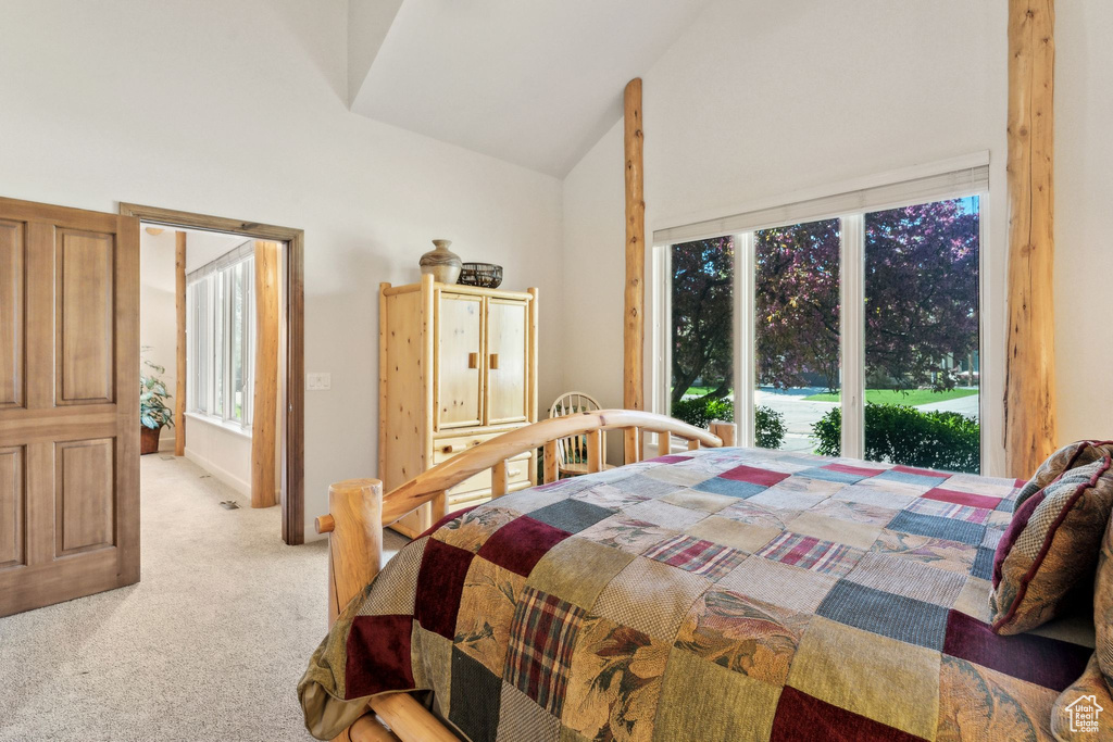 Bedroom with light carpet and high vaulted ceiling