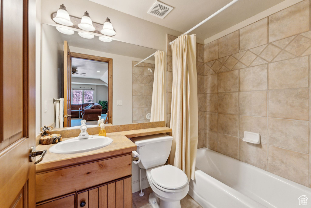 Ensuite bathroom with toilet, vanity, and shower / tub combo