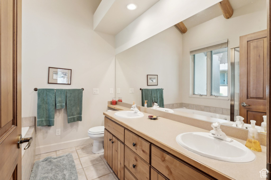 Full bathroom with tile patterned floors, toilet, a bath, and double vanity