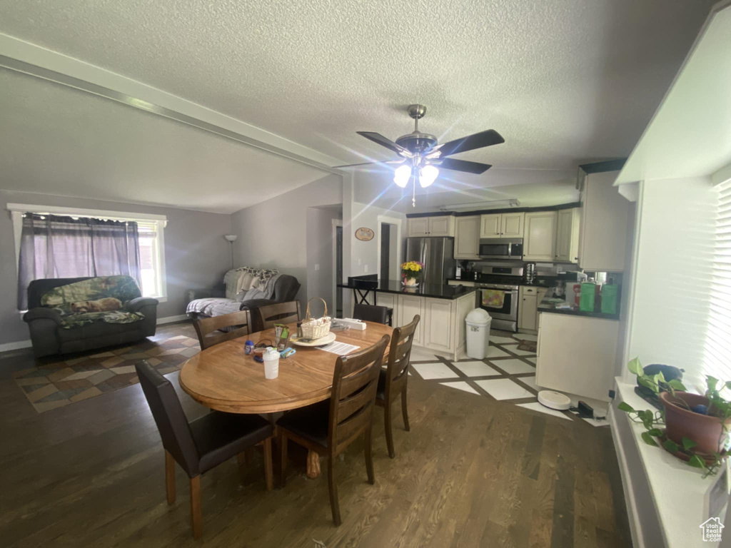 Dining room with ceiling fan, a textured ceiling, and wood finished floors