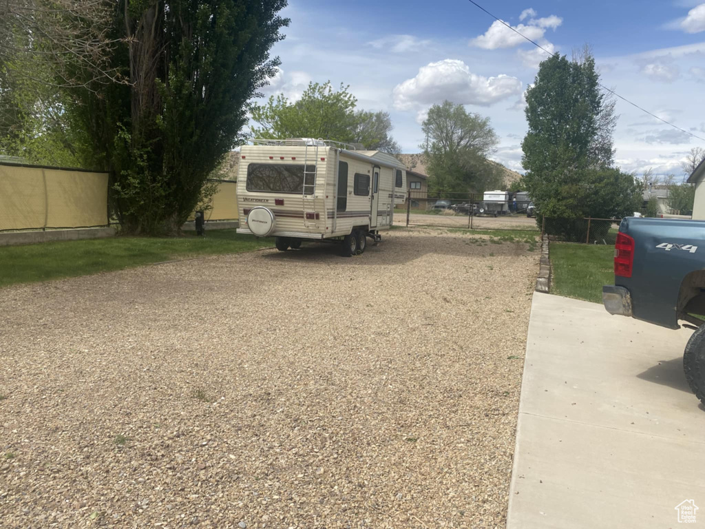 View of yard featuring fence and driveway