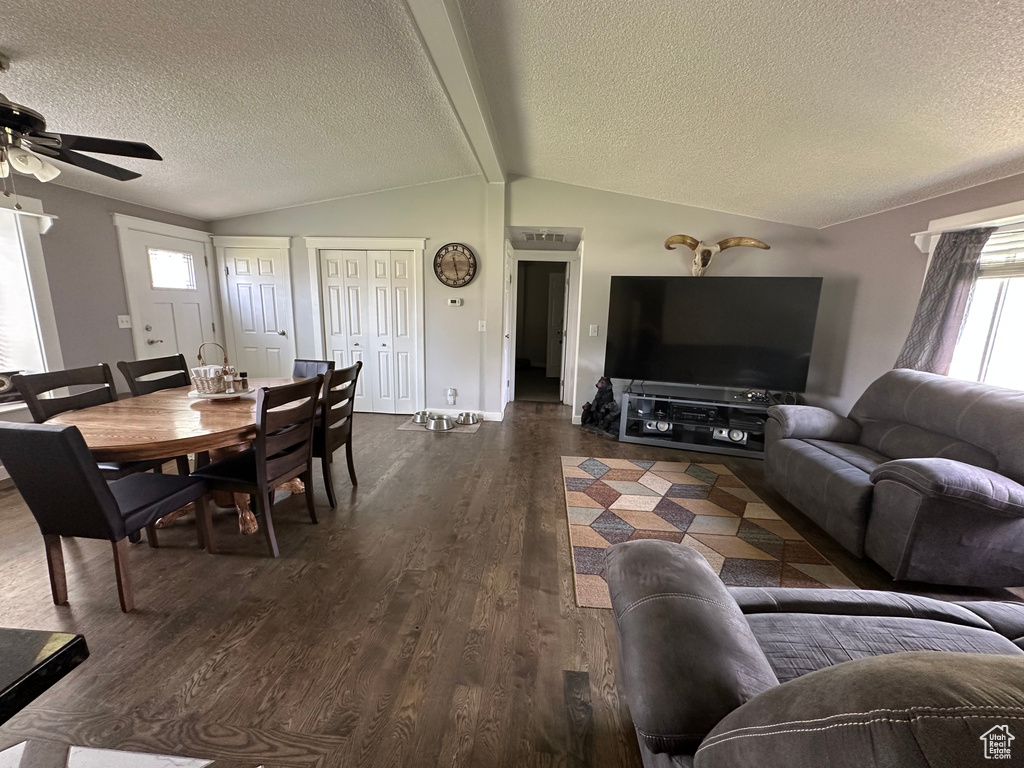 Dining room featuring a ceiling fan, a textured ceiling, dark wood-type flooring, and baseboards