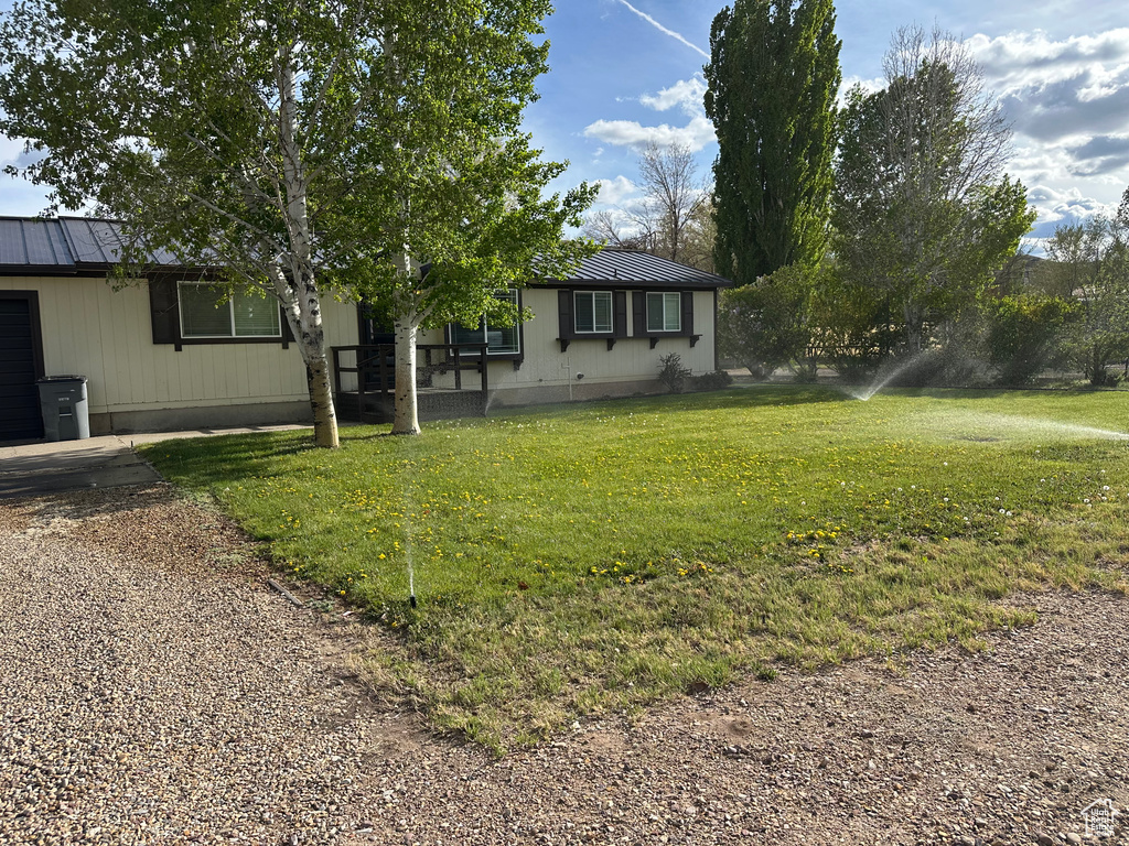 View of front of property featuring metal roof and a front lawn