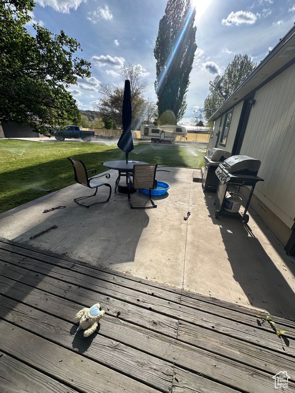 Deck featuring a patio, a lawn, and a grill