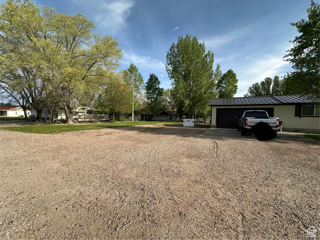 View of yard with an attached garage and driveway