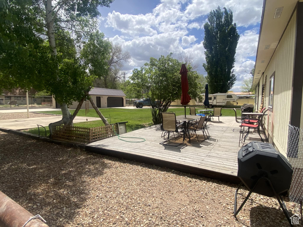 Wooden deck with outdoor dining area and a lawn