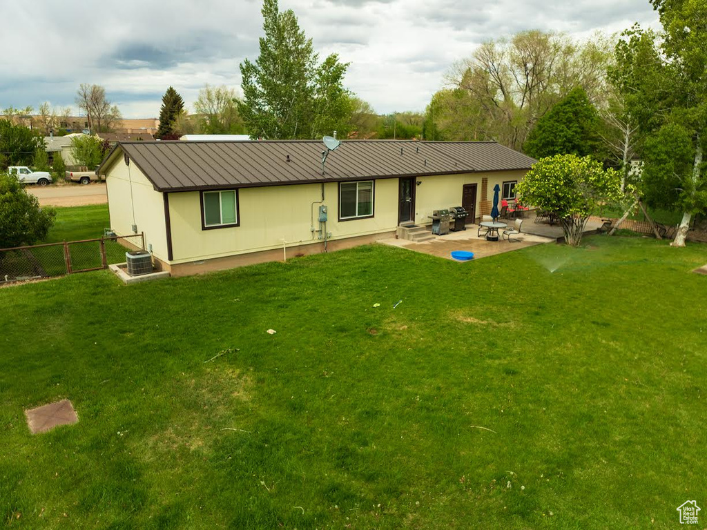Back of property with a patio, metal roof, and a standing seam roof