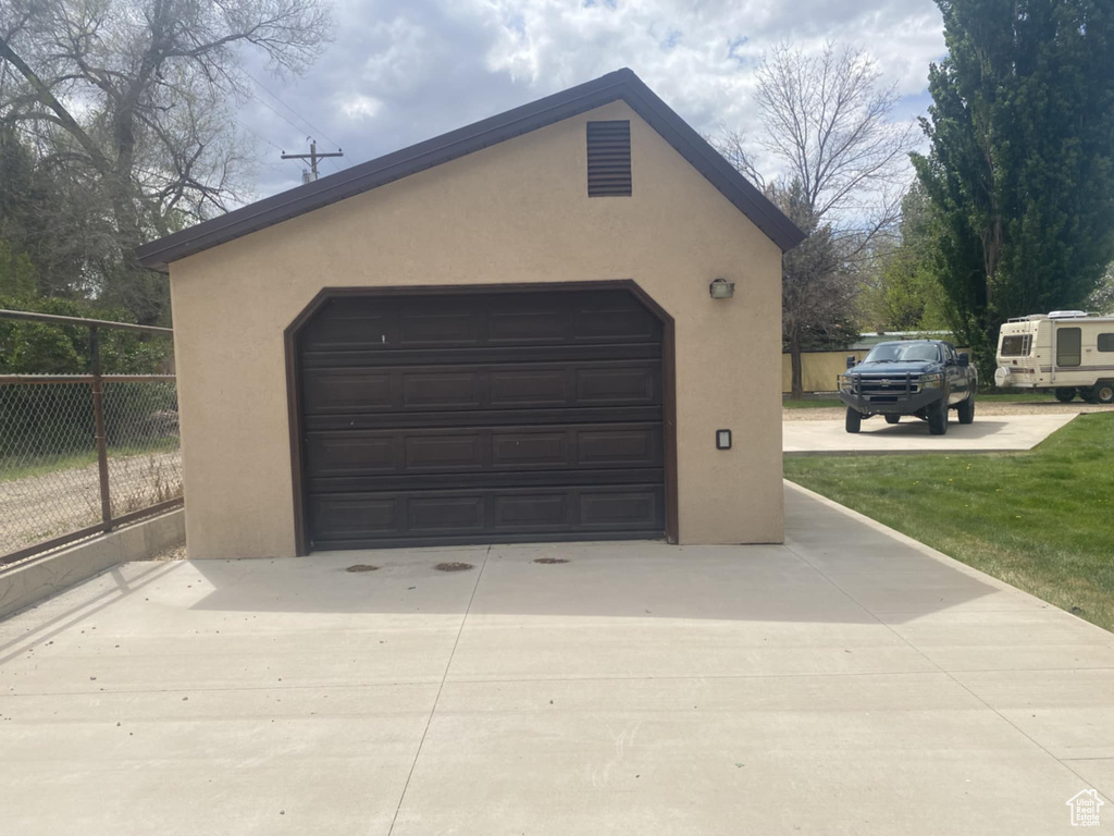 Detached garage featuring fence and driveway