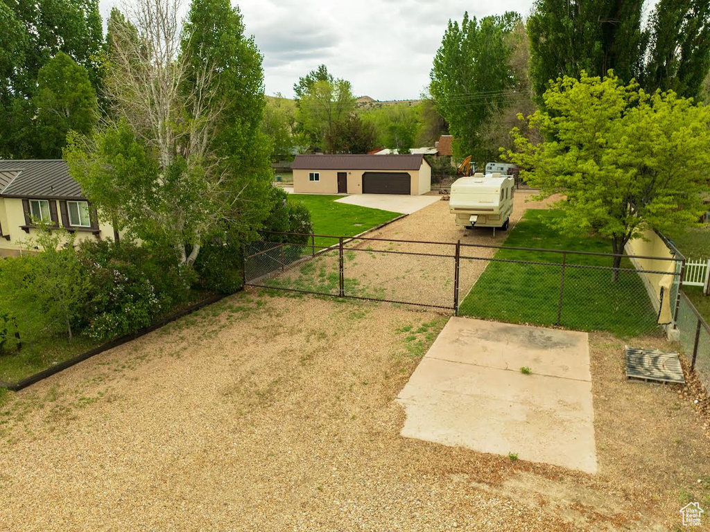 View of yard featuring a gate, a garage, and driveway