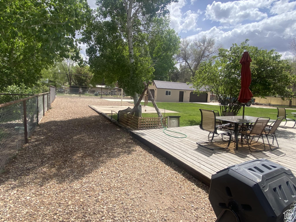 View of yard with a wooden deck and outdoor dining area
