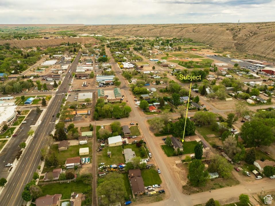 Aerial view of property's location with property boundaries highlighted, a main thoroughfare, and nearby suburban area