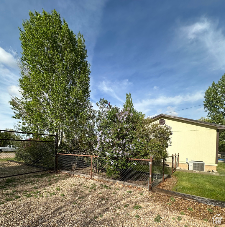 View of yard featuring fence and cooling unit