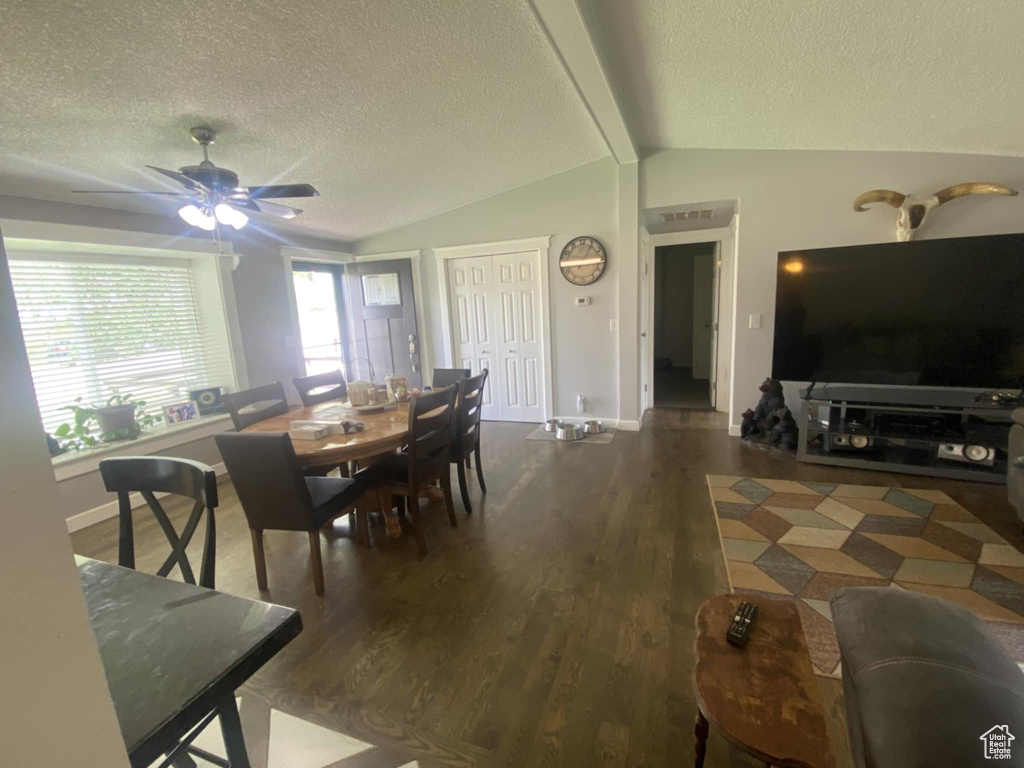 Dining room featuring a textured ceiling, wood finished floors, baseboards, and a ceiling fan