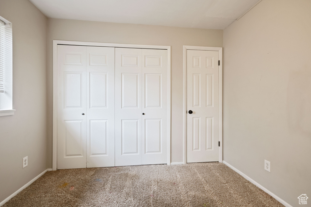 Unfurnished bedroom with carpet, baseboards, and a closet