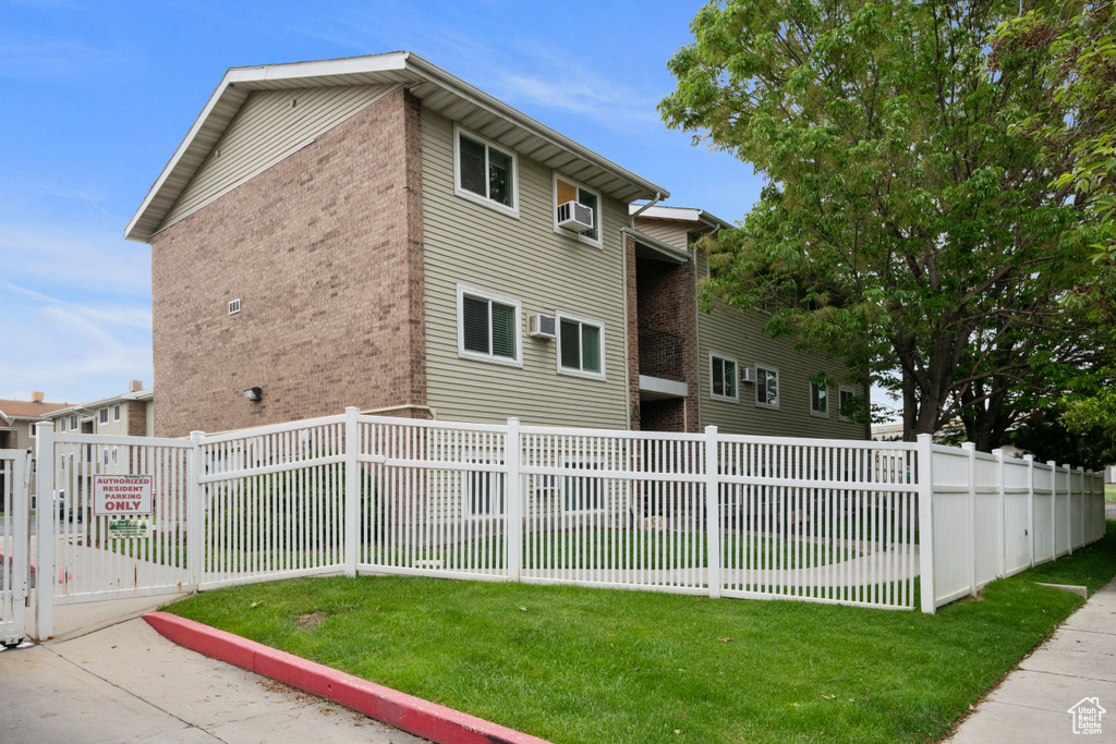 View of property exterior with brick siding and an AC wall unit