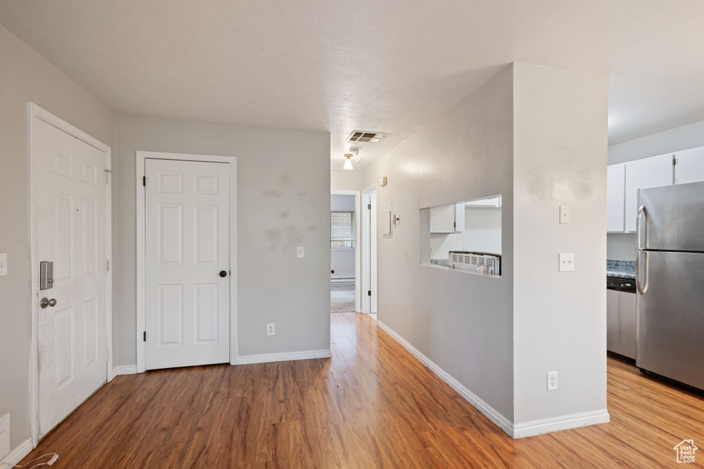Hallway featuring light wood-style flooring and baseboards