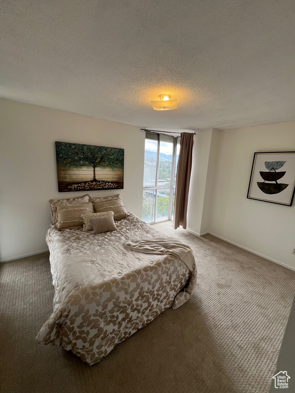 Bedroom with carpet, baseboards, and a textured ceiling