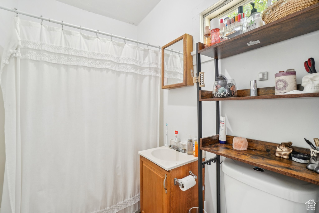 Full bath with toilet, vanity, and a shower with curtain