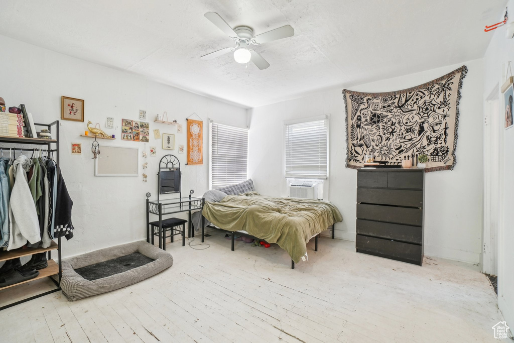 Bedroom with ceiling fan, cooling unit, and hardwood / wood-style floors