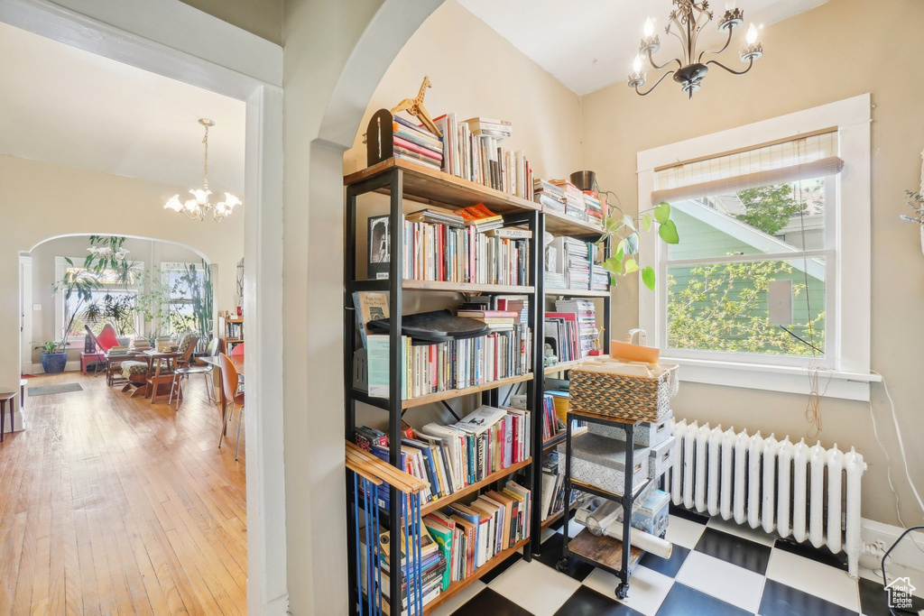 Living area featuring a chandelier, radiator, and hardwood / wood-style floors