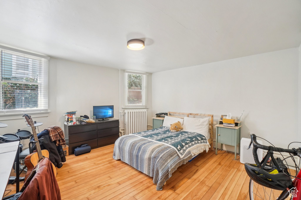 Bedroom with radiator and light wood-style flooring