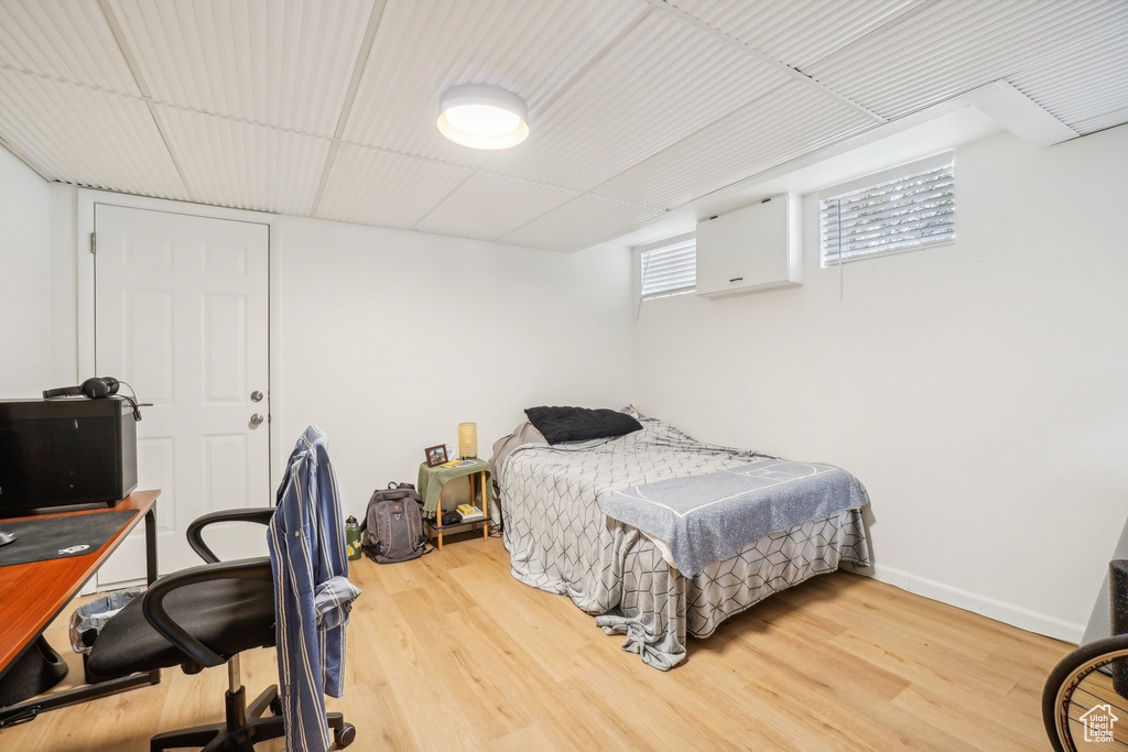 Bedroom with wood finished floors and an office area